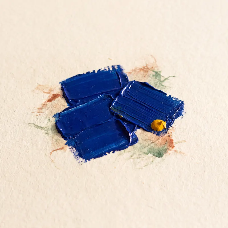 Thick strokes of blue oil paint on textured paper with visible brush marks, a small yellow drop, and faint green and brown stains.