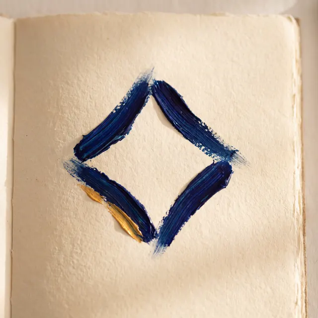 A diamond shape composed of four textured blue paint strokes on cream paper, featuring a small gold accent on the lower-left edge.